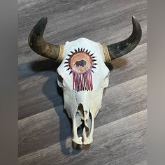 an animal skull with long horns on a wooden floor