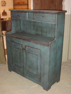 an old green wooden cabinet sitting in a room