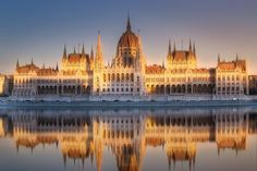 the parliament building is reflected in the water