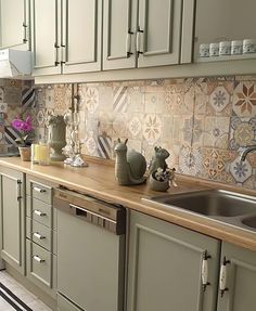 a kitchen with green cabinets and tile backsplash