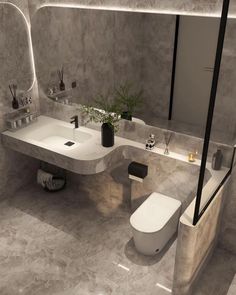 a modern bathroom with two sinks and a toilet in the middle, surrounded by concrete walls