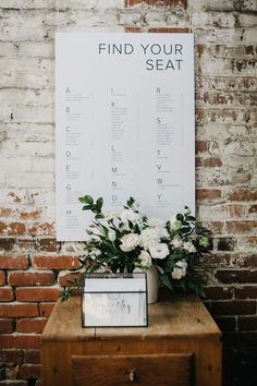 a table with flowers on it and a sign that says find your seat