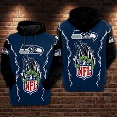 a blue and black nfl hoodie with the seattle football team on it, in front of a brick wall