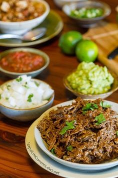 a table topped with plates and bowls filled with different types of food on top of it