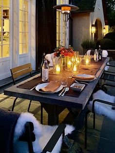 an outdoor dining table with candles on it