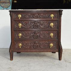 an ornate wooden chest of drawers with brass handles