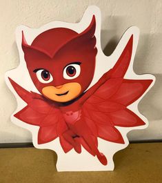 a cardboard cutout of a red bird with leaves on it's head and eyes