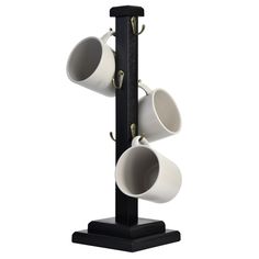 three coffee cups are hanging from a black stand with two white mugs on it