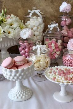 a table topped with lots of different types of candy and candies in glass containers