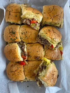 a bunch of sliders that are sitting on top of some wax paper and have been cut in half