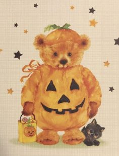 a teddy bear dressed up as a pumpkin with two kittens next to it on a white background