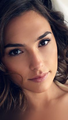 a close up of a woman with long hair and blue eyes looking at the camera