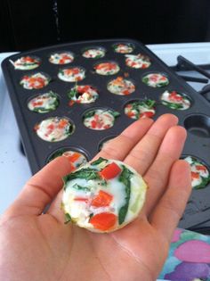 someone is holding up some food in front of a pan with other items on it