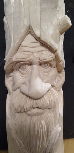 a statue of an old man with a beard and hat on it's head