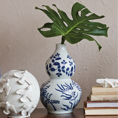 two white and blue vases sitting on top of a table next to each other