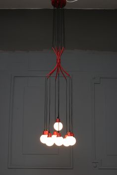 a chandelier with five lights hanging from it's sides in a room