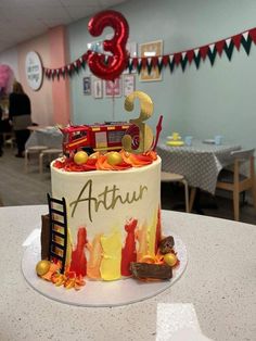 a birthday cake with the number three on it sitting on a table in a room