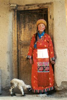 a woman standing in front of a door next to a dog