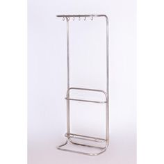 a metal rack with two hooks on it and one hanging from the top, against a white background