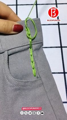 someone is stitching the green thread into their pants