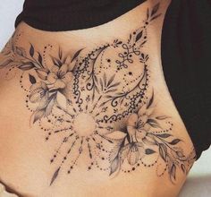 a woman's lower back tattoo with flowers on it