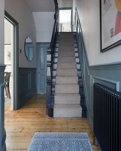 a staircase leading up to the first floor in a house with blue walls and wooden floors