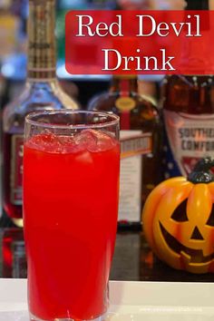 a glass filled with red devil drink sitting on top of a counter