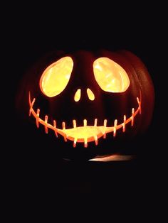 a jack o lantern with glowing eyes in the dark