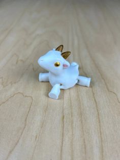 a small white toy sitting on top of a wooden table