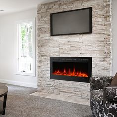 a living room filled with furniture and a flat screen tv mounted on the wall above a fire place