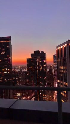 the city skyline is lit up at night with skyscrapers in the foreground and lights on