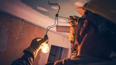 a man in hardhat working on a light fixture