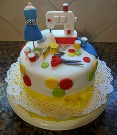 a cake decorated with sewing supplies on a table