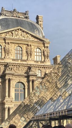 people are standing in front of a building with a glass pyramid on the top floor