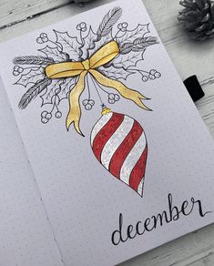 a christmas card with an ornament hanging from it's side and the word december written in black ink