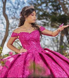 a woman in a pink dress is holding out her hand while wearing a tiara