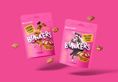 two packages of dog treats on a pink background