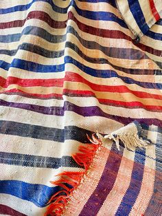 a colorful striped blanket with fringes on it