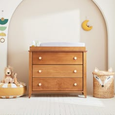 a baby's room with a dresser, crib and stuffed animals on the floor