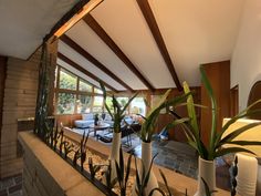 a living room filled with lots of furniture and plants on top of a stone counter