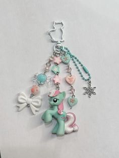 a key chain with charms attached to it's sides on a white table top