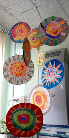 several colorful paper plates hanging from the ceiling