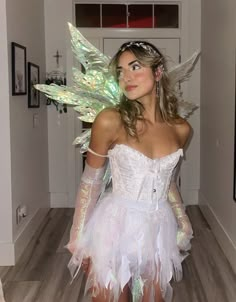 a woman in a white dress with wings on her head