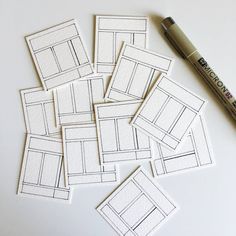 several pieces of white paper sitting on top of a table next to a marker and pen