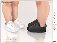 two pairs of white and black shoes with green accents on the soles are standing next to each other