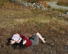 a woman is laying on the ground with her head in her hands and eyes closed