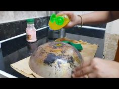 a person is using a spray bottle to clean an old helmet on top of a stove