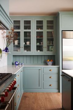 a kitchen with blue cabinets and wooden floors