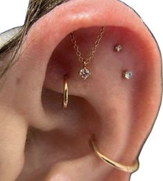 an ear with three different piercings attached to it