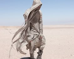 a woman in a star wars outfit is walking through the desert